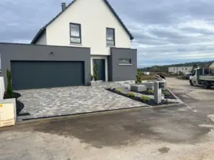 Cour pavée devant une maison contemporaine avec garage