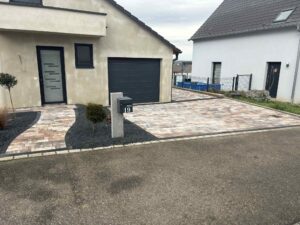 Entrée de maison et accès au garage en pavés aux tons rosés